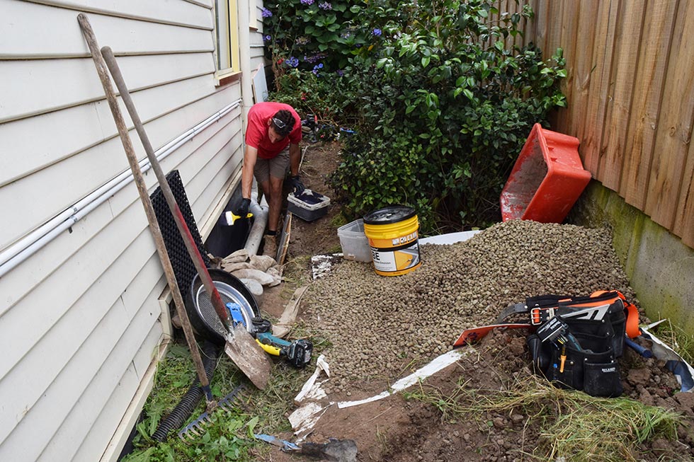 Image of a tradesman fixing soil moisture problems